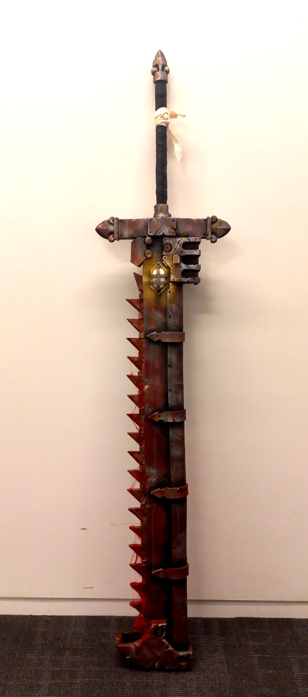 Final result of my Warhammer 40K Chainsword, with gore made of modpodge soaked unspun yarn applied to the teeth for extra panache.