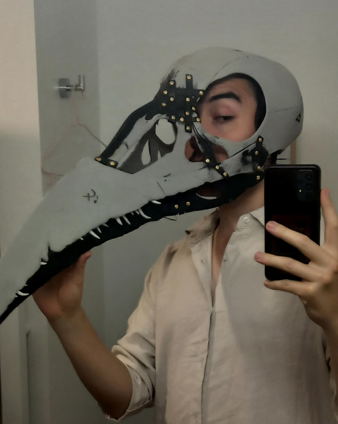 Work in progress photo of the head of the demon Orthax from Critical Role, made from EVA foam, with teeth made from thermoplastic. I'm currently refining a wire mechanism inside the skull so that his jaw will move with my own while wearing him.